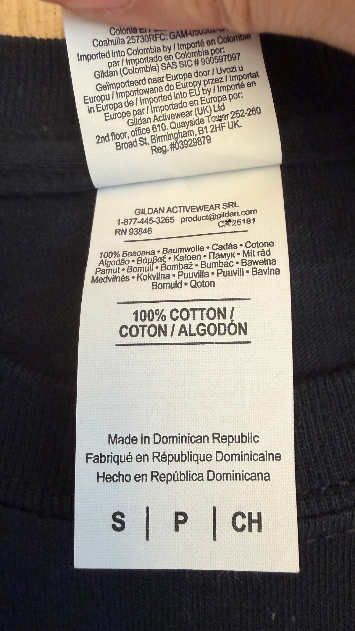 Close-up view of the inner fabric care tag on a Gildan Ultra Cotton t-shirt displaying 100% Cotton material composition and manufacturing details