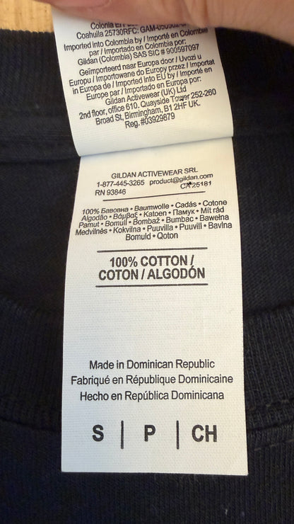 Close-up view of the inner fabric care tag on a Gildan Ultra Cotton t-shirt displaying 100% Cotton material composition and manufacturing details