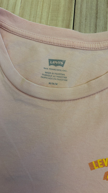 Close-up view of the inner neck area of a light pink Levi's t-shirt showing the printed Levi's Batwing logo, San Francisco, Cal., Made in Pakistan, and size M