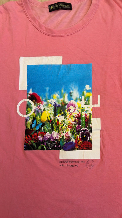 Front view of a pink Mika Ninagawa x 24 Hour Television 39th charity t-shirt featuring a colorful floral photo print with a butterfly and text graphics