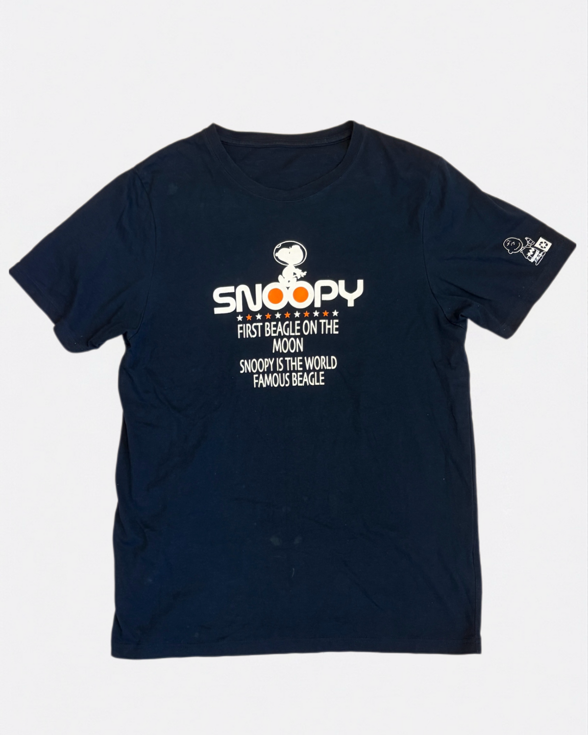 Navy blue Peanuts t-shirt featuring Astronaut Snoopy First Beagle on the Moon graphic text print, front view