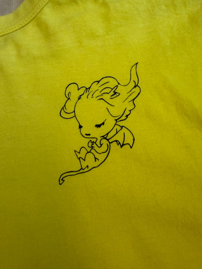 Back view of a yellow Yoshitaka Amano x 24 Hour Television 37th charity t-shirt featuring a black line art illustration of a sleeping winged fantasy character