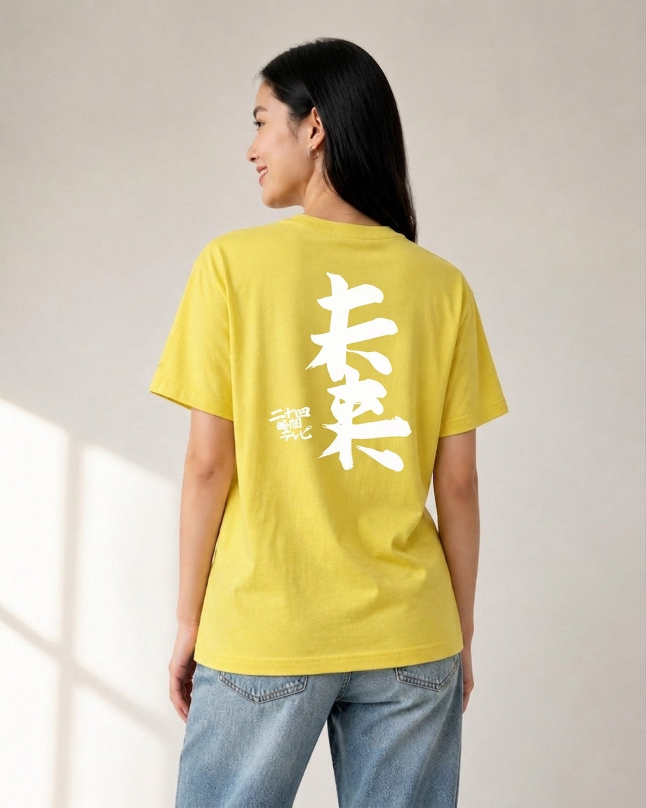 Woman wearing yellow Yoshitomo Nara x 24 Hour Television 2012 charity t-shirt from the back, displaying large white Japanese calligraphy and small red seal mark.